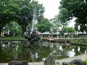 公園内の池と噴水の画像