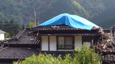 瓦屋根が崩れた住宅の写真