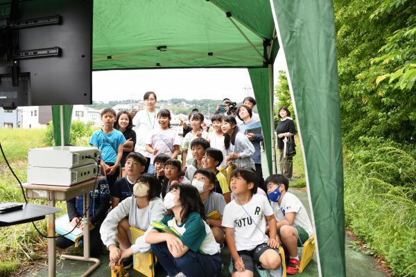 ドローンが撮影する映像をモニターで確認する児童らの写真